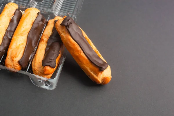 Eclairs Met Crème Vulling Doordrenkt Met Chocolade Een Zwarte Achtergrond — Stockfoto