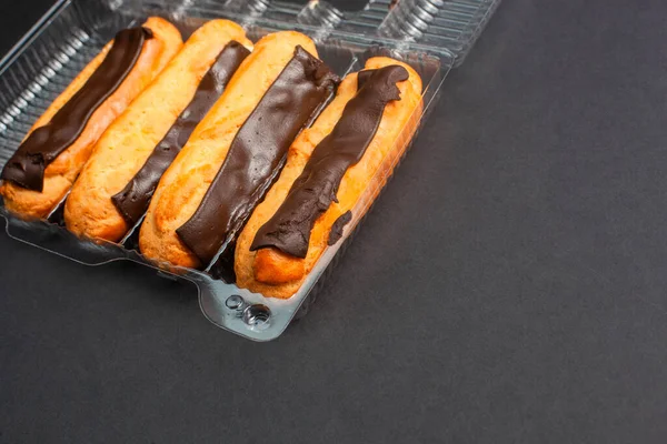 Eclairs Met Crème Vulling Doordrenkt Met Chocolade Een Zwarte Achtergrond — Stockfoto