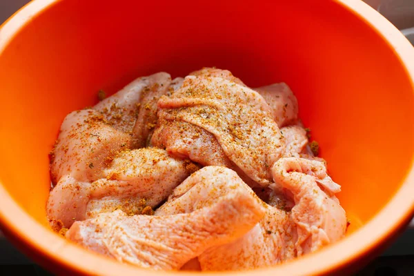 Pişmemiş tavuk dilimleri, zerdeçal ezmesiyle tatlandırılmış, plastik kasenin içinde. Kapat, üst görünüm