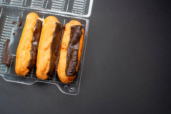 Eclairs Met Crème Vulling Doordrenkt Met Chocolade Een Zwarte Achtergrond — Stockfoto