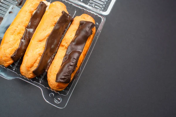 Eclairs Met Crème Vulling Doordrenkt Met Chocolade Een Zwarte Achtergrond — Stockfoto