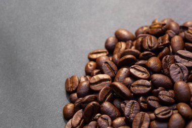 Kahverengi kahve çekirdekleri, koyu arkaplanda tohum. Koyu espresso, aroma, siyah kafein içeceği. Yakından izole edilmiş enerji kahvesi, kapuçino malzemesi. Metni boş yere kopyala