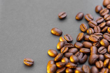 Kahverengi kahve çekirdekleri, koyu arkaplanda tohum. Koyu espresso, aroma, siyah kafein içeceği. Yakından izole edilmiş enerji kahvesi, kapuçino malzemesi. Metni boş yere kopyala