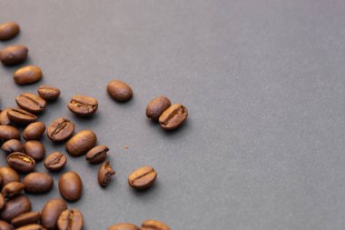 Kahverengi kahve çekirdekleri, koyu arkaplanda tohum. Koyu espresso, aroma, siyah kafein içeceği. Yakından izole edilmiş enerji kahvesi, kapuçino malzemesi. Metni boş yere kopyala