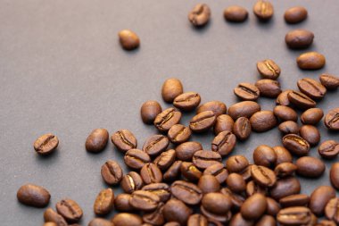 Kahverengi kahve çekirdekleri, koyu arkaplanda tohum. Koyu espresso, aroma, siyah kafein içeceği. Yakından izole edilmiş enerji kahvesi, kapuçino malzemesi. Metni boş yere kopyala