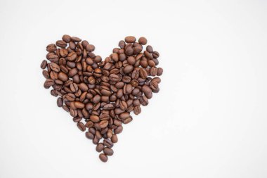 Kahve çekirdeği kalbi beyaz arka planda izole edilmiş. Kalp şeklinde kahve çekirdekleri. En iyi yemek..