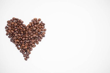 Kahve çekirdeği kalbi beyaz arka planda izole edilmiş. Kalp şeklinde kahve çekirdekleri. En iyi yemek..