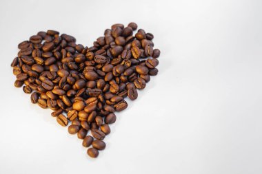Kahve çekirdeği kalbi beyaz arka planda izole edilmiş. Kalp şeklinde kahve çekirdekleri. En iyi yemek..