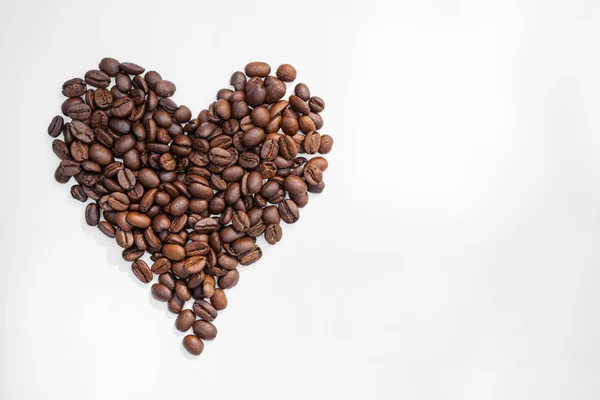 コーヒー豆の心臓は白い背景に隔離される 心の形をしたコーヒー豆 上からの眺め — ストック写真