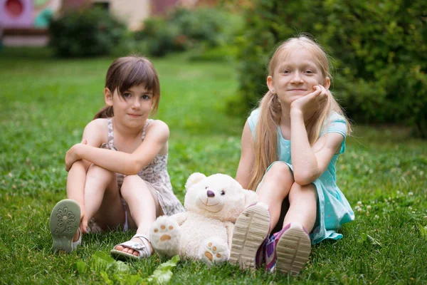 Маленькі Красиві Дівчата Подружки Сидять Галявині Своїм Іграшковим Плюшевим Ведмедем — стокове фото