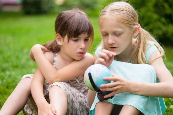 Küçük Kızlar Kız Çimenlerin Üzerine Oturmuş Güzel Glob Bak — Stok fotoğraf