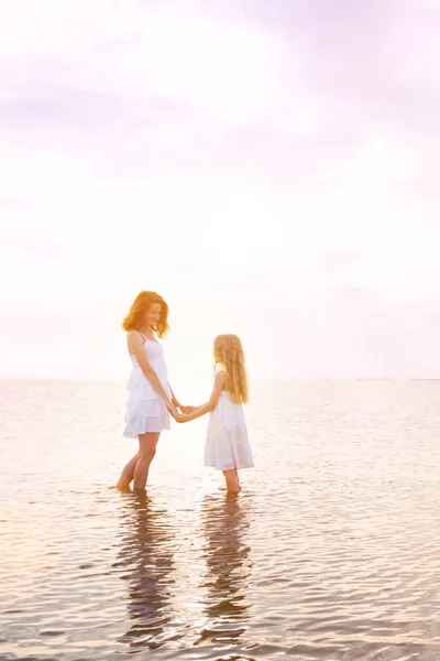 ママと夕日で海沿い歩いて白いドレスの娘で幸せな週末 アゾフ海 Ukrain でウクライナの風景 — ストック写真
