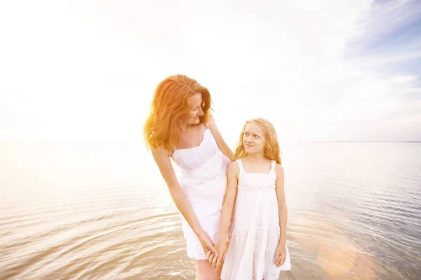 ママと夕日で海沿い歩いて白いドレスの娘で幸せな週末 アゾフ海 Ukrain でウクライナの風景 — ストック写真