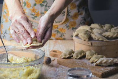 Ukrainian traditional bakery products - Making pierogies by female hands. Rustic style. Retro Phot clipart