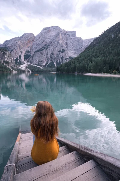 秋女坐在码头上 风景著名的蒂罗尔湖 Braies 白云岩医院 — 图库照片