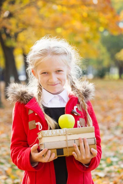 Scolaretta Sorridente Tiene Libri Apple Nelle Sue Mani Nel Parco — Foto Stock