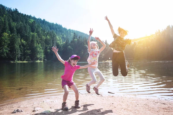 ハイキングに小さな子供たち Synevyr の海岸にジャンプ楽しい幸せな子供 — ストック写真