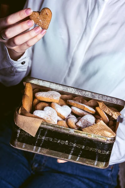 自制蛋糕的情人节 女孩拿着一个在一个听的形状与姜饼饼干复古盒 — 图库照片