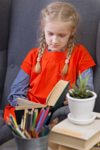 Kleines Mädchen Sitzt Auf Einem Stuhl Und Liest Ein Buh — Stockfoto