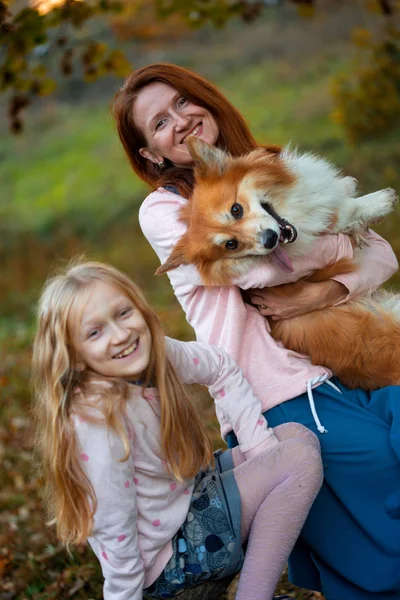 陽気な家族 ママと娘と秋の公園でふわふわコーギー笑顔 — ストック写真
