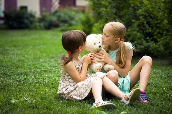 Onun Oyuncak Oyuncak Ayı Ile Çimenlikte Oturan Küçük Güzel Kızlar — Stok fotoğraf
