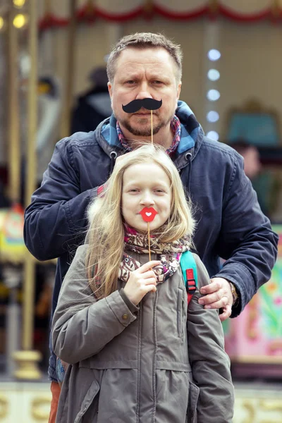 dad and daughter have fun on the background of the French carousel in Pari