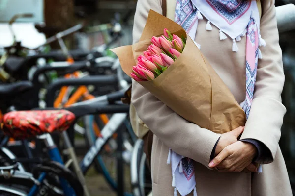 女孩捧着一束郁金香站在 Amsterda 的街道上 — 图库照片