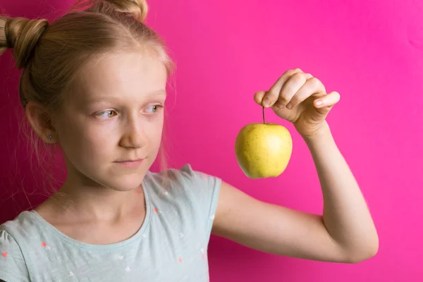 Liten Vacker Flicka Blondin Med Apple Rosa Bakgrund — Stockfoto