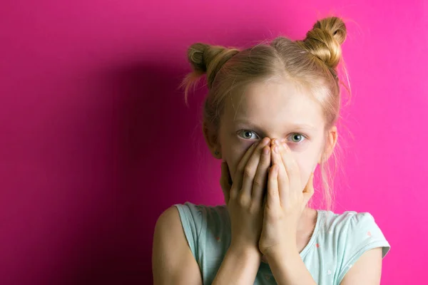 Kleine Schöne Mädchen Blondine Auf Rosa Hintergrund Bedeckt Ihren Mund — Stockfoto