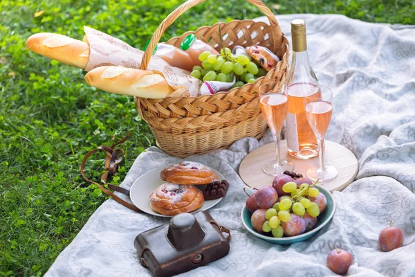 在草地上野餐 法式面包 葡萄酒 葡萄和卷在一个篮子上的绿色肝 — 图库照片