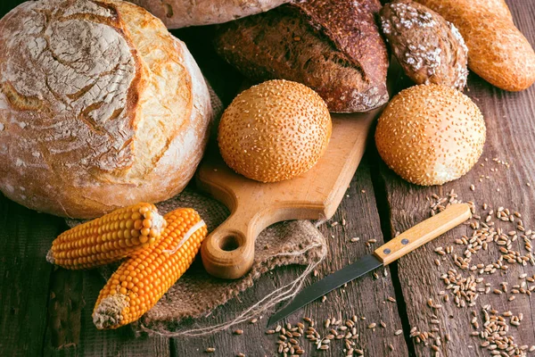Frisches Brot und Weizen auf dem Holz — Stockfoto