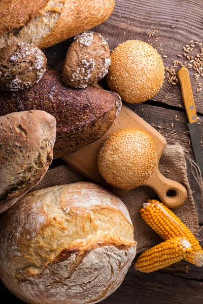 Frisches Brot und Weizen auf dem Holz — Stockfoto