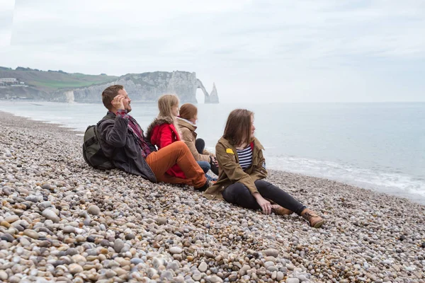 Dad with mom and two daughters sitting on the beach of  Etretat — Stock Photo, Image