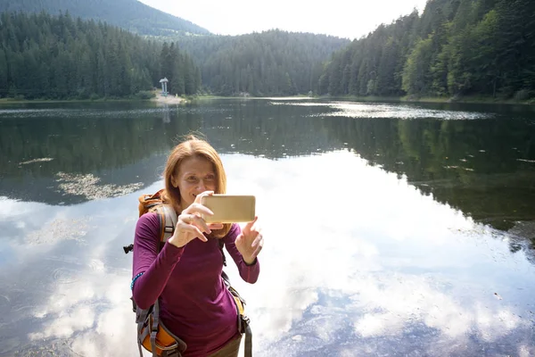 Туристическая девушка на горном озере — стоковое фото