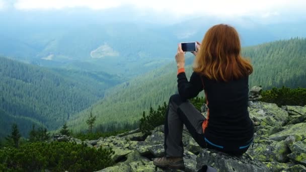 女の子ハイカーが山の頂上に立っているの写真を撮影 — ストック動画