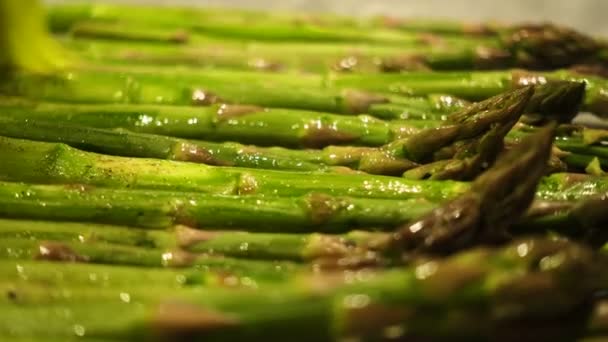 在烘烤特写前用刷子涂油新鲜绿色芦笋茎 — 图库视频影像
