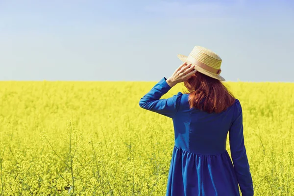 Girl walking in a field of yellow rapeseed — Stock Photo, Image