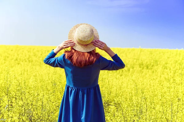 Menina andando em um campo de colza amarela — Fotografia de Stock