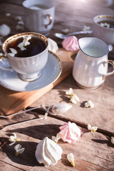 Still Life-kopjes thee, meringues en bloemen — Stockfoto