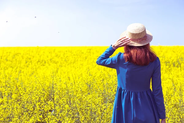 Chica caminando en un campo de colza amarilla — Foto de Stock