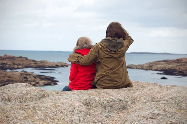 Las hermanas están sentadas en la orilla del océano —  Fotos de Stock