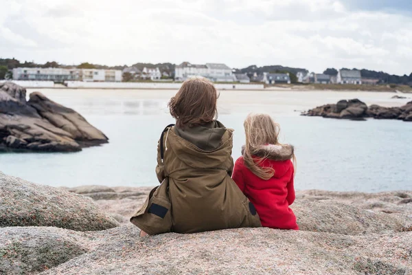 Le sorelle sono sedute sulla riva dell'oceano — Foto Stock