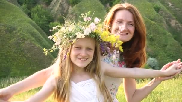 快乐的母亲和女儿 带着花环在黄昏的草地上享受着快乐 — 图库视频影像
