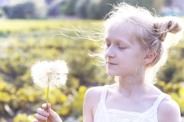 Meisje bedrijf paardebloem — Stockfoto