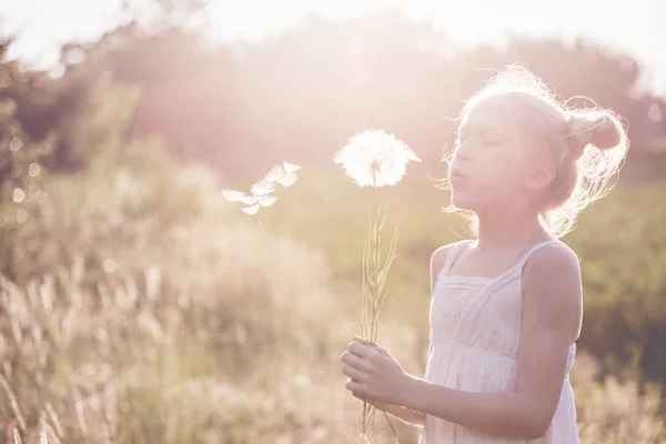 Meisje bedrijf paardebloem — Stockfoto