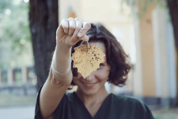 Meisje houdt een geel blad — Stockfoto