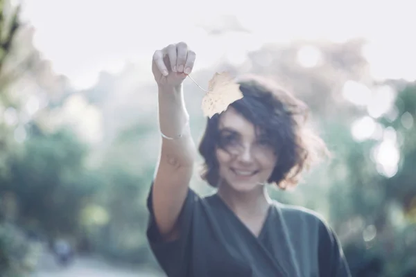 Meisje houdt een geel blad — Stockfoto