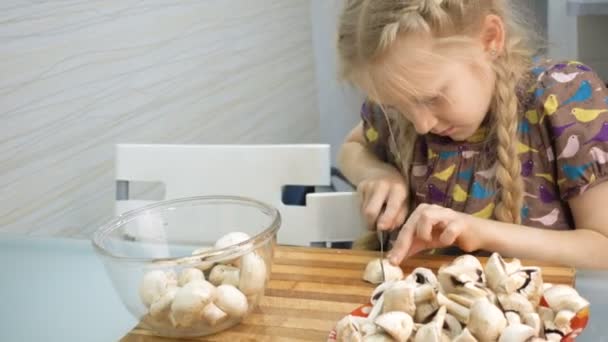 キノコを切り 台所で食事を準備する子供の女の子 — ストック動画