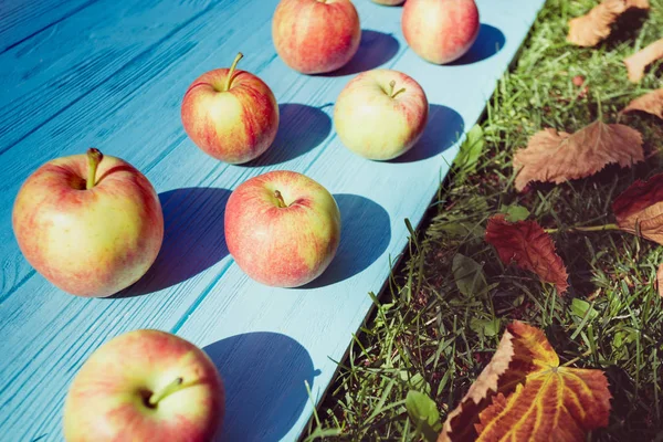 Saftiga äpplen på en trä bakgrund — Stockfoto
