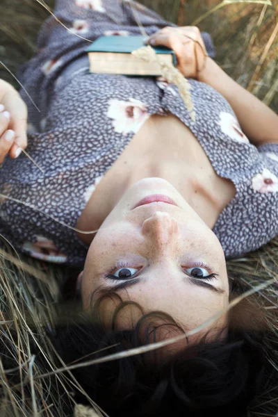 Девочка лежит в сухой траве — стоковое фото